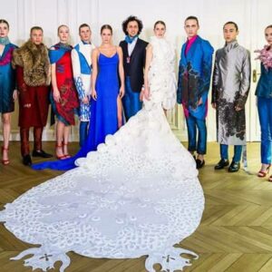 Douze modèles portant des créations du styliste Epehr Maghsoudi, entourant une robe blanche spectaculaire.