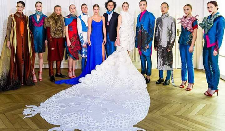Douze modèles portant des créations du styliste Epehr Maghsoudi, entourant une robe blanche spectaculaire.
