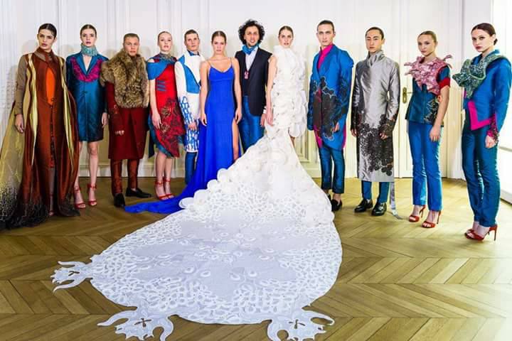 Douze modèles portant des créations du styliste Epehr Maghsoudi, entourant une robe blanche spectaculaire.