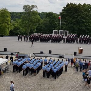 Cérémonie des pompiers de Paris en 2017, avec des uniformes colorés et un public rassemblé sous un ciel dégagé.