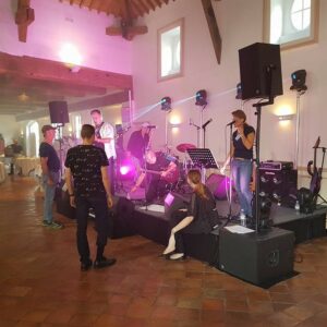 Scène de concert au Domaine de Grand Maison avec musiciens, matériel de sono et éclairage en préparation.