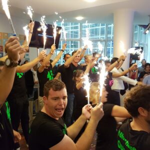 Groupe festif lors d'un événement, brandissant des étincelles, célébrant l'énergie et l'enthousiasme au sein d'une entreprise.