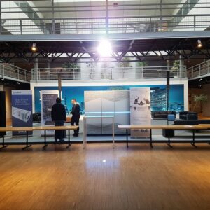 Stand d'Atos/Bull à une exposition, présentant des équipements de son et d'éclairage. Deux personnes discutent devant un panneau d'affichage.