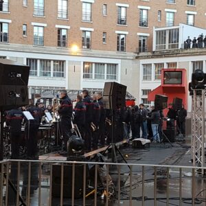 Hommage à Johnny Hallyday avec un concert en plein air, featuring des musiciens et du matériel de sono.