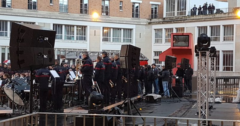 Hommage à Johnny Hallyday avec un concert en plein air, featuring des musiciens et du matériel de sono.