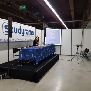 Stand de Studyrama avec un présentateur, un écran et des sièges au salon.