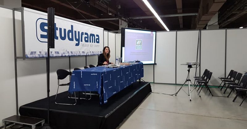 Stand de Studyrama avec un présentateur, un écran et des sièges au salon.