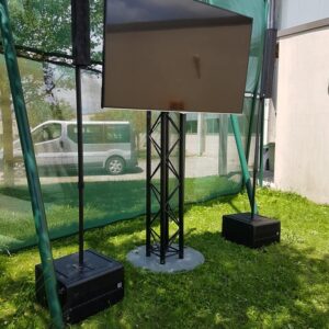 Écran monté sur un support avec enceintes, pour la retransmission de la finale de Roland-Garros en extérieur.
