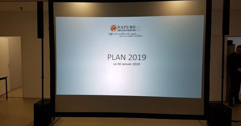 Écran de projection affichant "PLAN 2019" lors d'un événement pour Nature et Découvertes, le 30 janvier 2019.