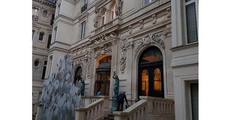 Entrée de la Gallerie Gaggeneau, avec des sculptures, des escaliers et un décor architectural élaboré.