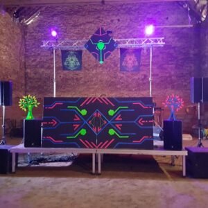 Scène de soirée techno avec équipements audio et éclairage, décorée de motifs colorés, le 1er juin 2019.