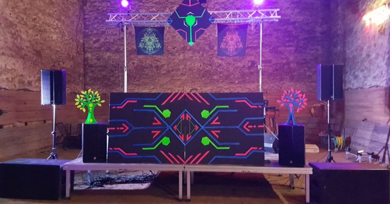 Scène de soirée techno avec équipements audio et éclairage, décorée de motifs colorés, le 1er juin 2019.