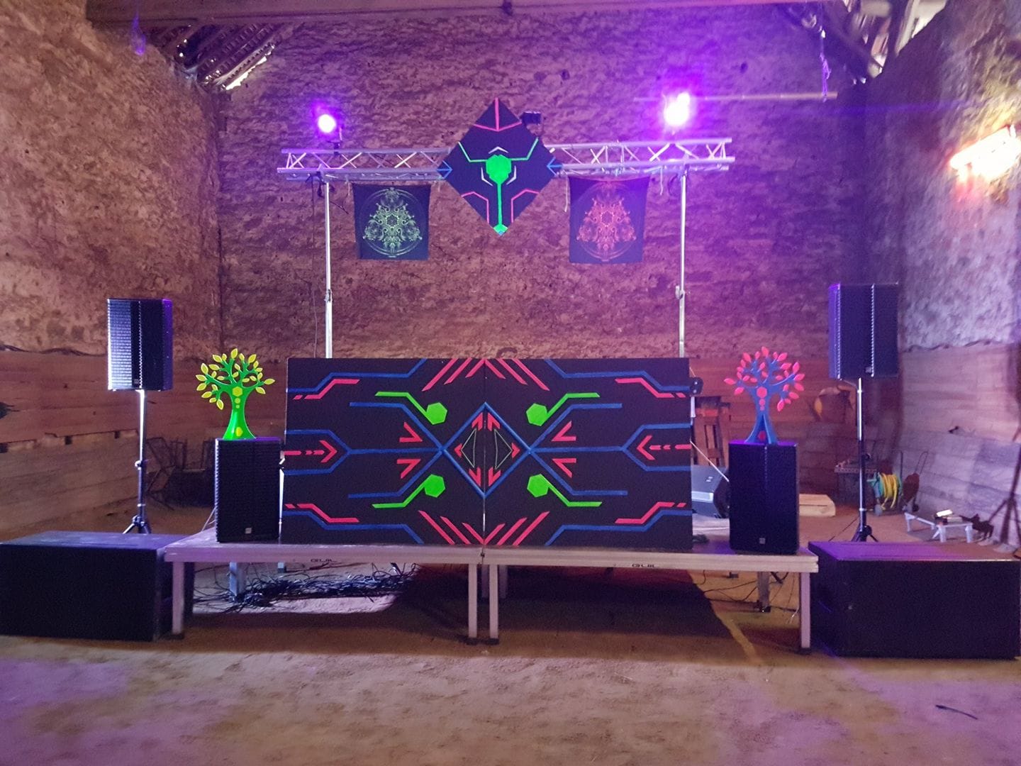Scène de soirée techno avec équipements audio et éclairage, décorée de motifs colorés, le 1er juin 2019.
