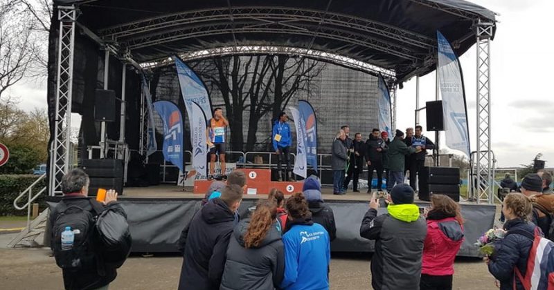 Cérémonie de remise des prix lors du Trail du 12 janvier 2019, Val d'Europe Athlétisme, avec des spectateurs et des athlètes sur scène.