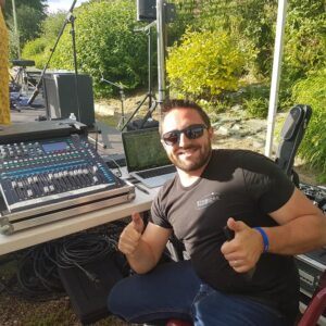 Technicien souriant à une console de mixage lors de la Fête de la musique à Coignières, le 21 juin 2019.