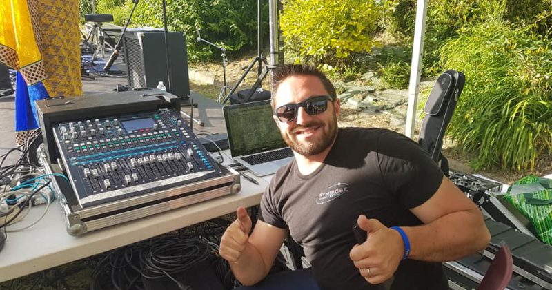 Technicien souriant à une console de mixage lors de la Fête de la musique à Coignières, le 21 juin 2019.