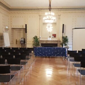 Salle de conférence à l'Université de Paris, avec chaises noires, estrade et matériel audiovisuels pour un événement.