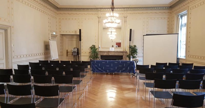 Salle de conférence à l'Université de Paris, avec chaises noires, estrade et matériel audiovisuels pour un événement.