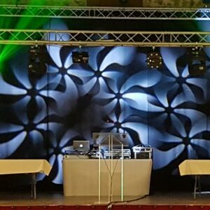 Installation de son et éclairage pour la soirée Meulan, avec scène, tables et jeux de lumière colorés.