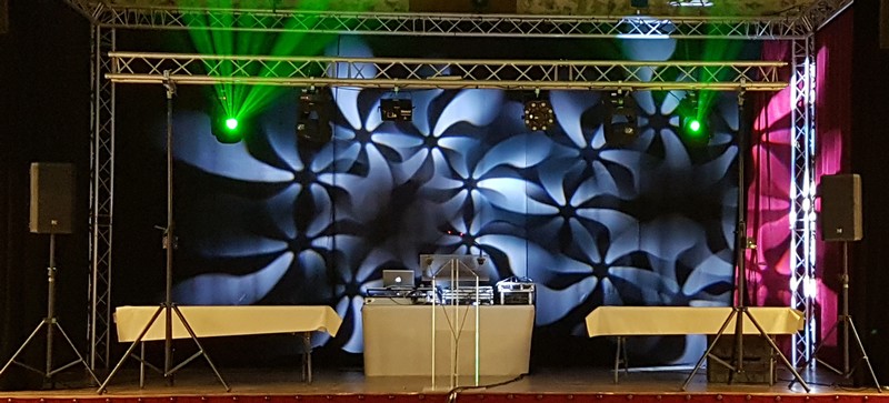 Installation de son et éclairage pour la soirée Meulan, avec scène, tables et jeux de lumière colorés.