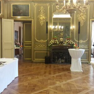 Intérieur élégant de l'ambassade néerlandaise, avec tables décorées et lumière naturelle.