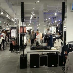 Intérieur d'un magasin New Look avec un espace de sono et d'éclairage, des clients regardant des vêtements.