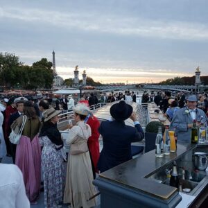 Concert philharmonique sur une péniche à Paris, ambiance festive avec des invités en costume d'époque.