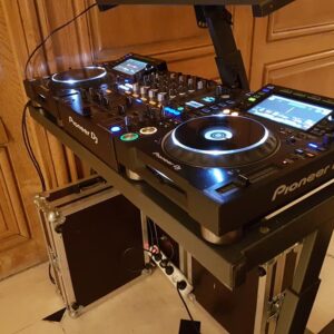 Poste de DJ Pioneer installé pour une soirée à Paris, mettant en avant équipements de sono et éclairage.