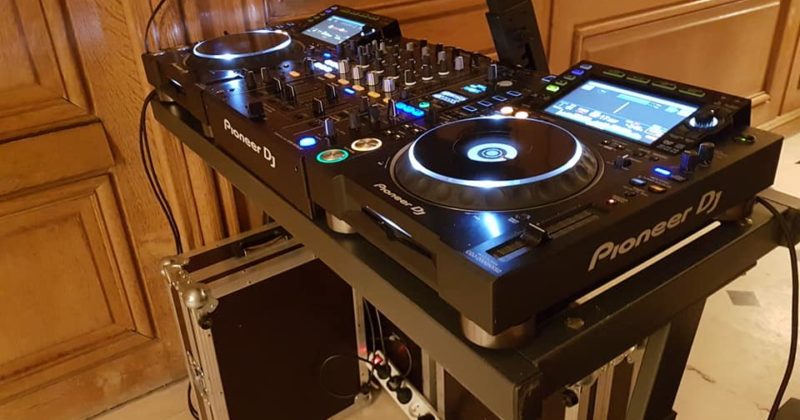 Poste de DJ Pioneer installé pour une soirée à Paris, mettant en avant équipements de sono et éclairage.