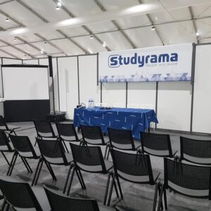 Salle de conférence avec chaises disposées, écran projeté et table pour l'événement Symbiose à Paris, 23 novembre 2019.