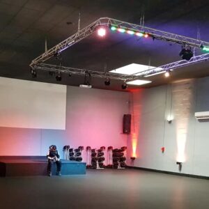 Salle de spectacle avec éclairage multicolore et équipements audio, préparée pour un événement.