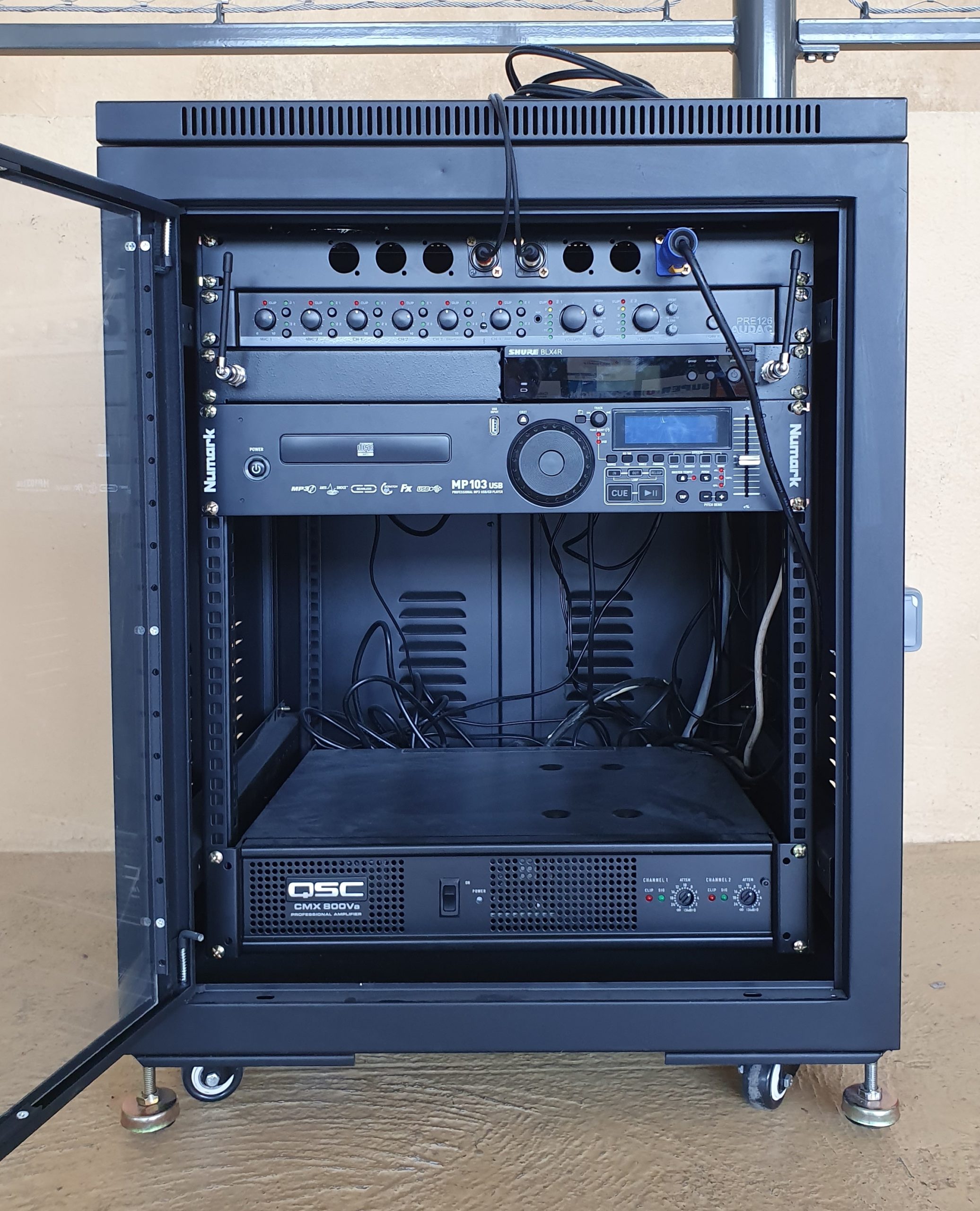 Équipement audio dans un rack professionnel, comprenant divers appareils de son et de contrôle, installé au gymnase Montbauron.