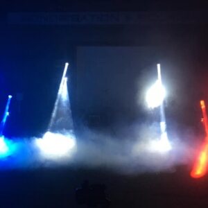 Spectacle lumineux en hommage aux soignants, avec faisceaux lumineux bleus et rouges dans une ambiance brumeuse.