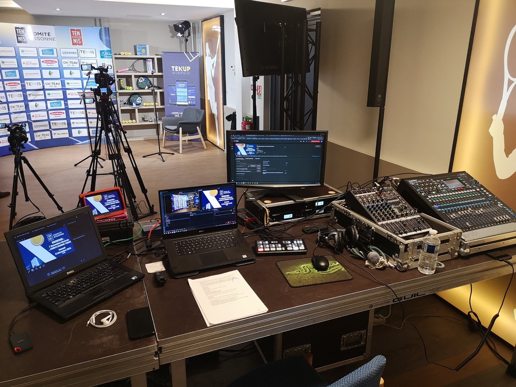 Poste de diffusion avec ordinateurs et table de mixage pour live streaming d'événements.