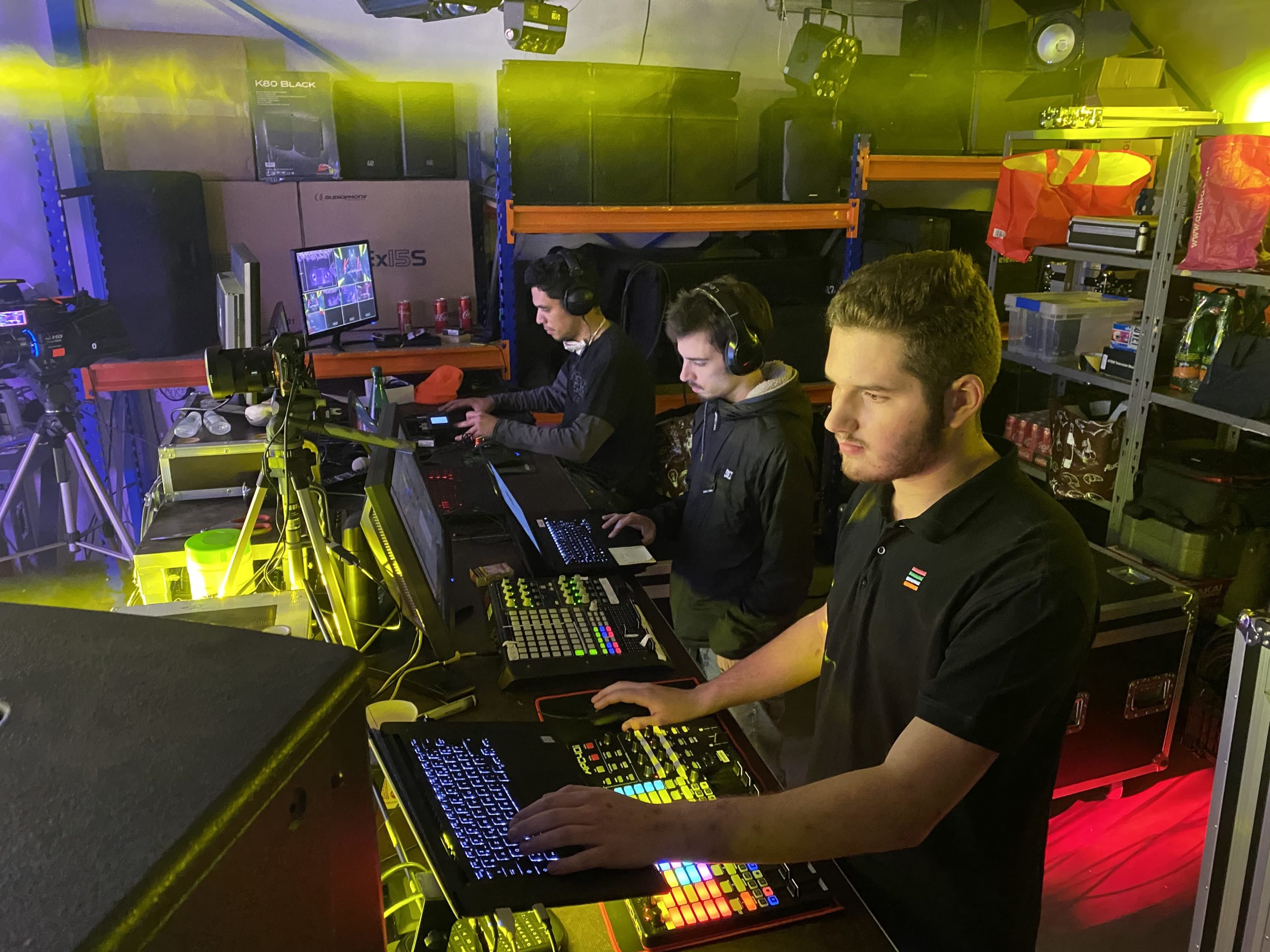 Équipe technique au travail lors d'un light show en hommage au personnel médical, avec des éclairages colorés et des équipements audio.