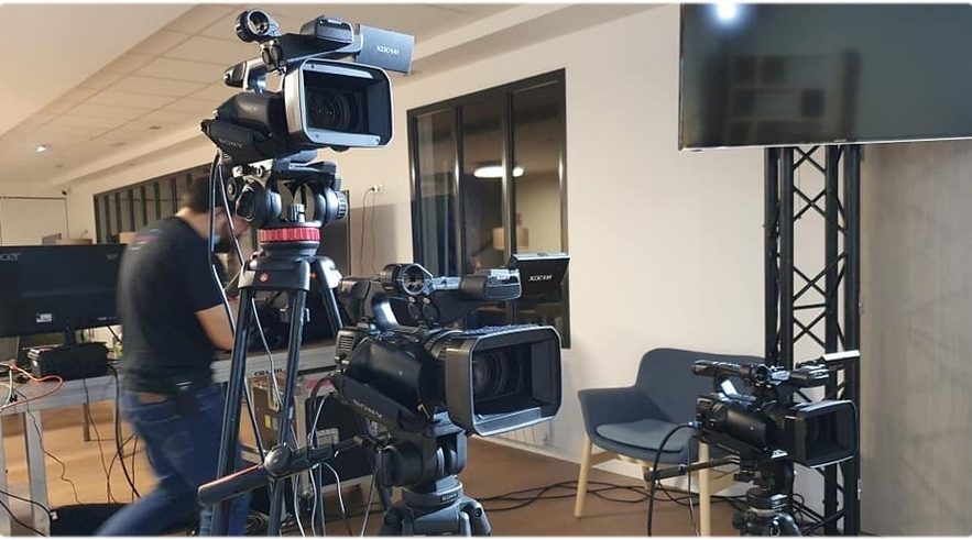 Équipement de production vidéo avec plusieurs caméras sur trépieds dans un espace de travail.
