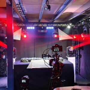 Studio de live streaming avec matériel de son et éclairage, ambiance lumineuse et caméras prêtes pour l'événement.