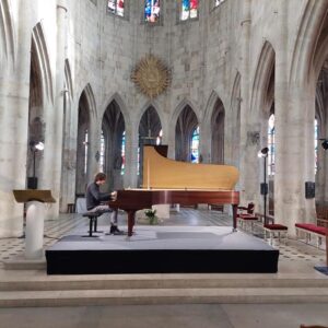 Un pianiste joue sur scène dans une église pendant le festival des Journées de Ravel à Montfort-l'Amaury.