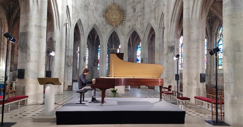 Un pianiste joue sur scène dans une église pendant le festival des Journées de Ravel à Montfort-l'Amaury.