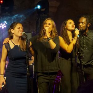 Concert du 30 novembre 2021 avec Zazie, plusieurs artistes chantent ensemble sur scène, ambiance festive.