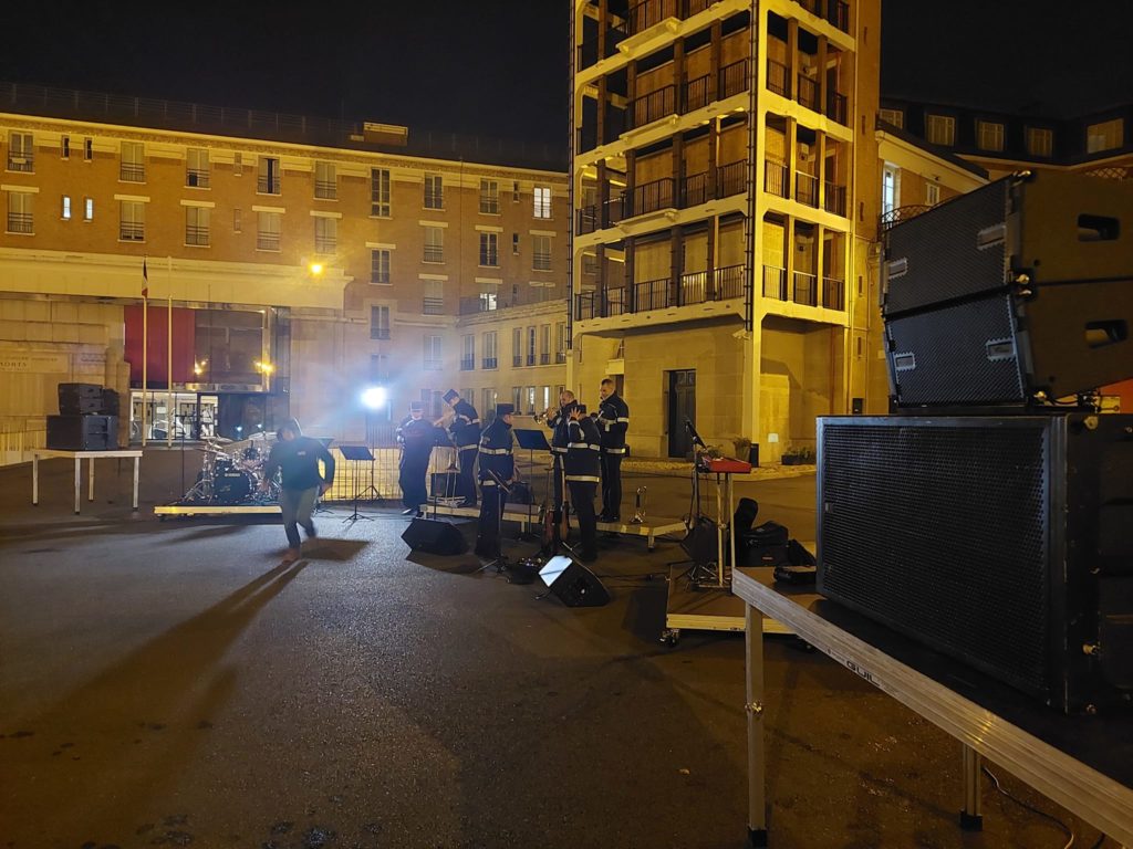 Les musiciens des pompiers de Paris finalisent les préparatifs pour le concert de la Sainte Barbe. Équipement sonore installé.