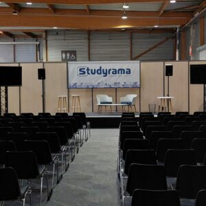 Salle de conférence pour l'événement Studyrama à Paris avec rangées de sièges et podium.