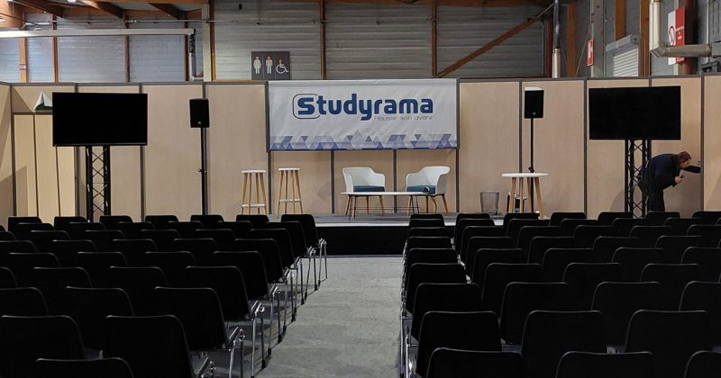 Salle de conférence pour l'événement Studyrama à Paris avec rangées de sièges et podium.