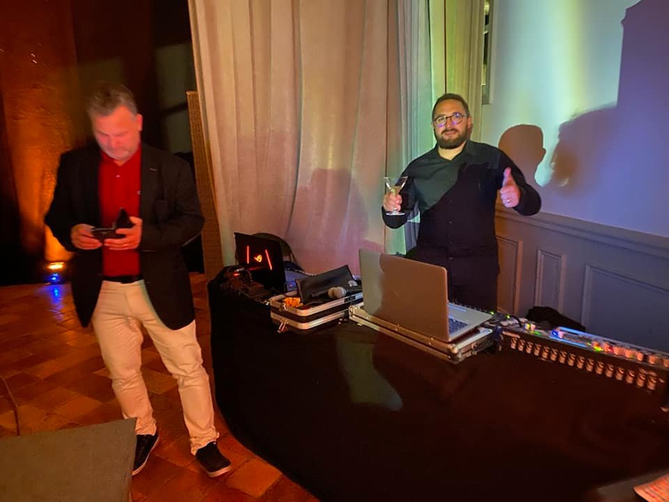Deux hommes lors d'un mariage au Domaine de Grand-Maison, l'un avec un cocktail et l'autre regardant son téléphone.