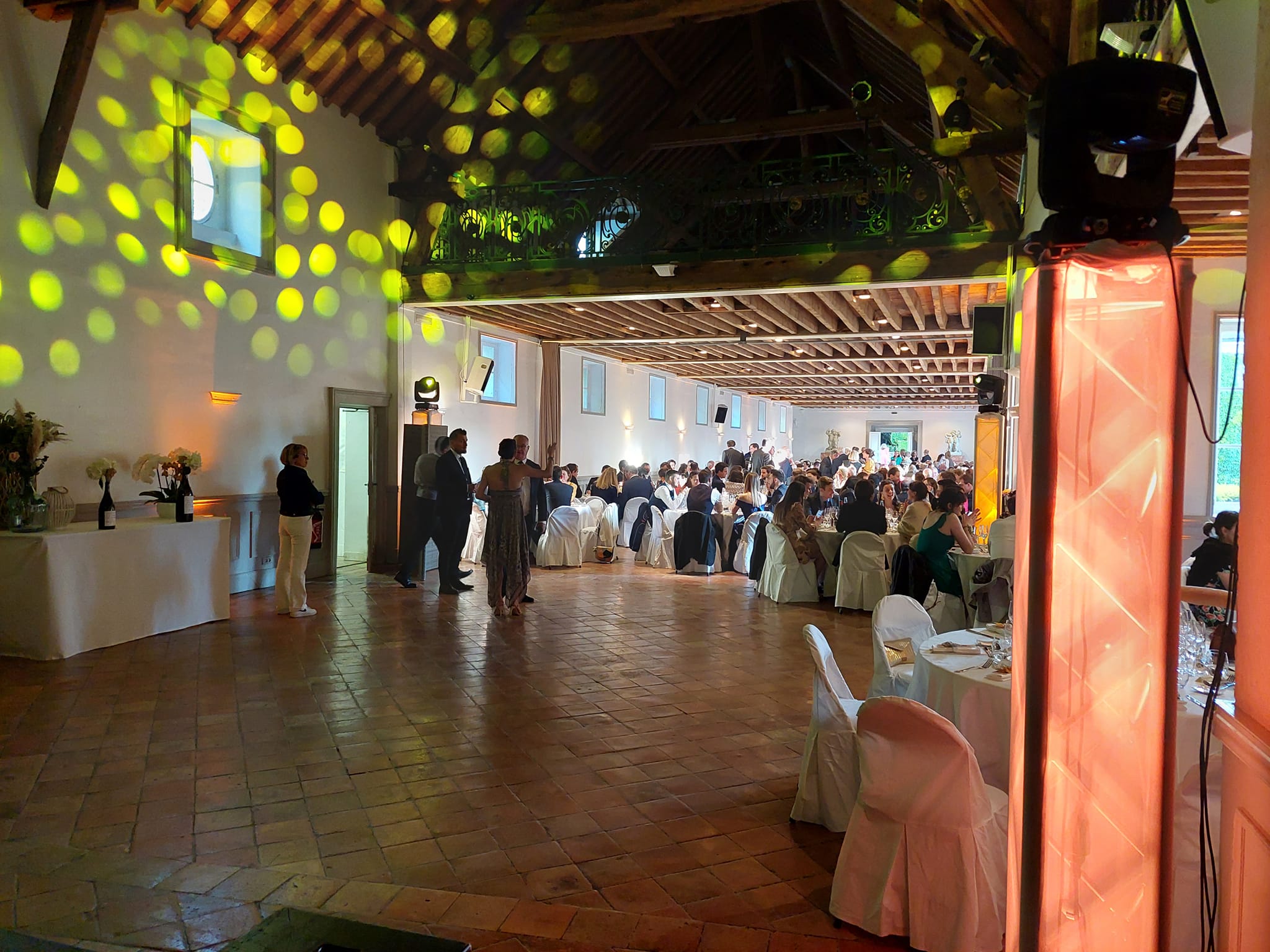 Salle de réception animée pour un mariage au Domaine de Grand-Maison, avec éclairage coloré et invités.