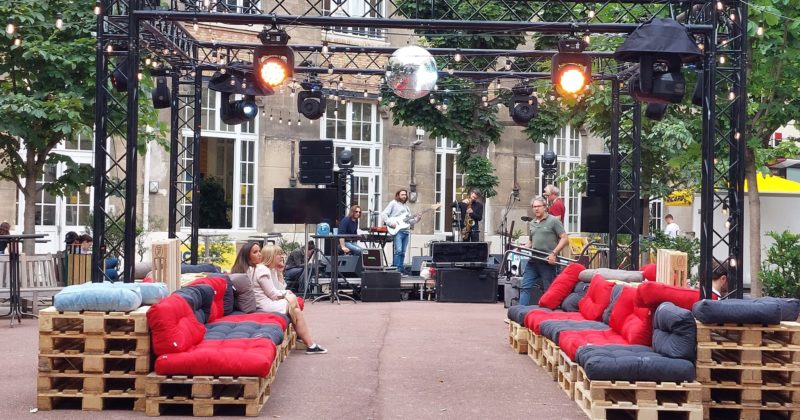 Scène aménagée avec canapés palettes et éclairage, lors de la soirée du 10 juin 2022, organisée par Symbiose Organisation.