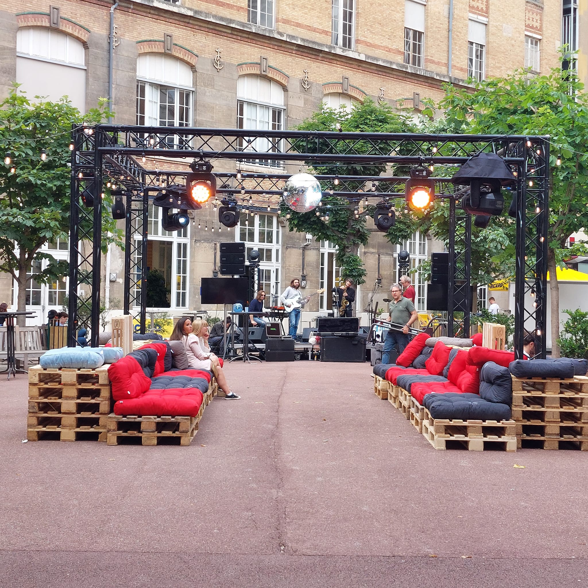Scène aménagée avec canapés palettes et éclairage, lors de la soirée du 10 juin 2022, organisée par Symbiose Organisation.