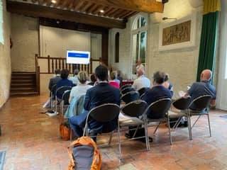 Participants assistent à une réunion avec plusieurs écrans dans une salle à Grand-Maison, le 24 juin 2022.
