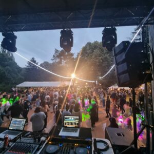 Foule festive dans une soirée à Bougival, avec équipement sonore et éclairage en action.