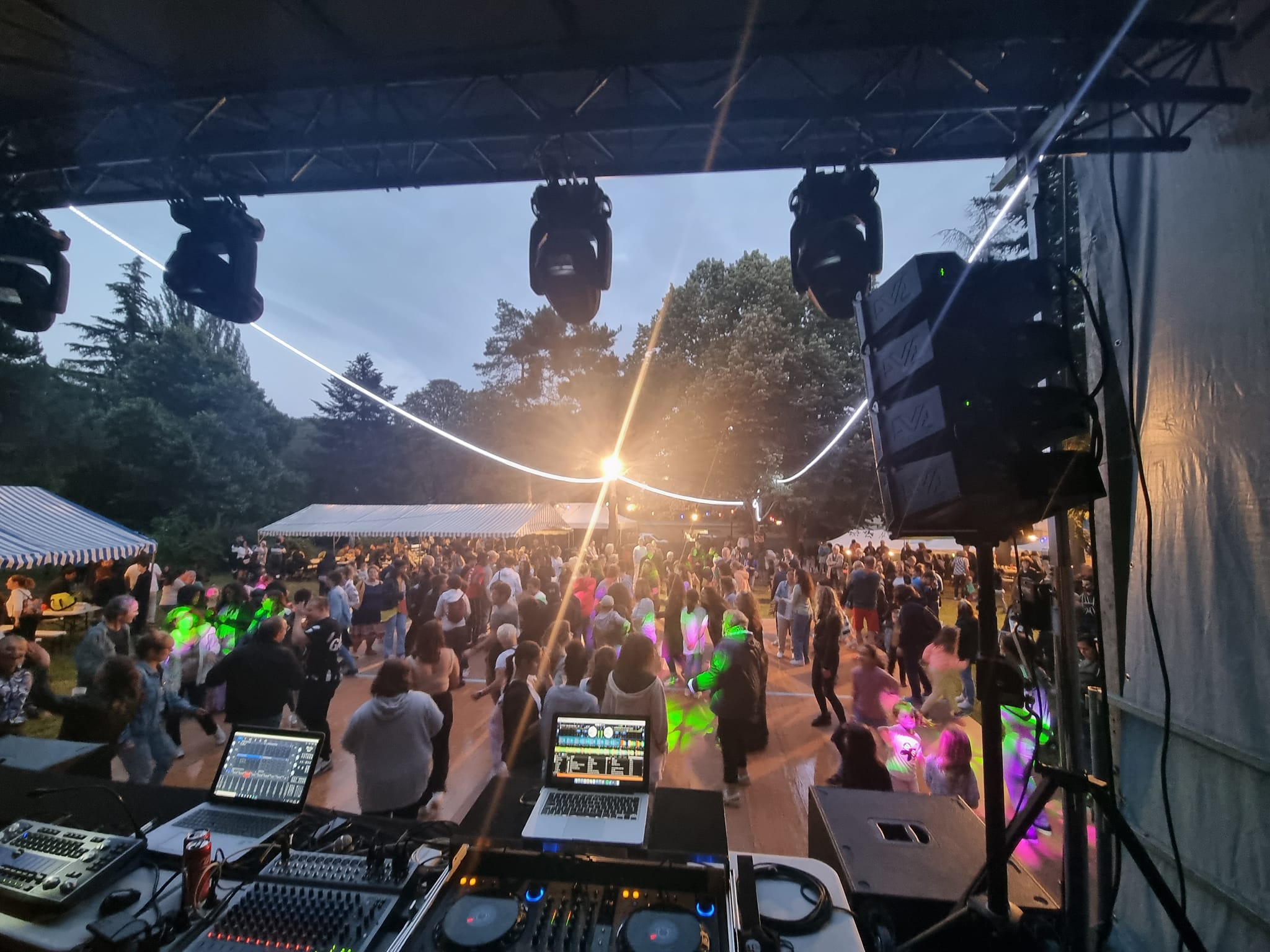 Foule festive dans une soirée à Bougival, avec équipement sonore et éclairage en action.